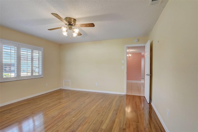 spare room with a textured ceiling, ceiling fan, and light wood-type flooring