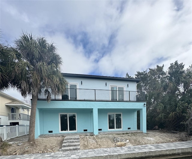 exterior space with a balcony and stucco siding