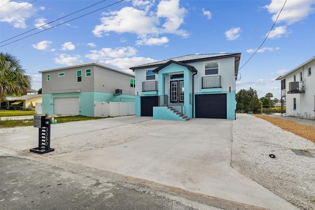 3380 Holly Springs Dr, Hernando Beach, FL 34607 - raised beach house with a garage, concrete driveway, a standing seam roof, and a metal roof
