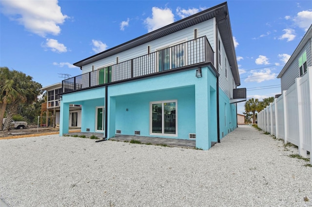 3380 Holly Springs Dr, Hernando Beach, FL 34607 - rear view of house featuring a balcony and stucco siding