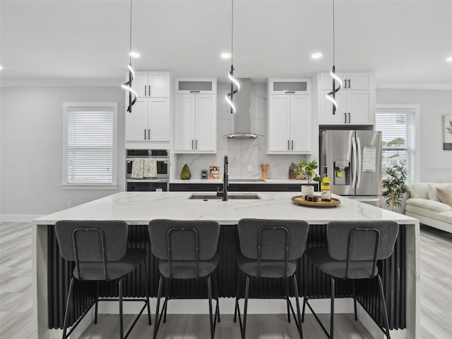 3380 Holly Springs Dr, Hernando Beach, FL 34607 - kitchen with stainless steel fridge with ice dispenser, crown molding, wall chimney range hood, a large island with sink, and decorative backsplash
