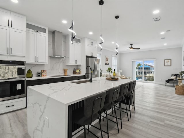 3380 Holly Springs Dr, Hernando Beach, FL 34607 - kitchen featuring stainless steel appliances, wall chimney range hood, decorative backsplash, an island with sink, and open floor plan