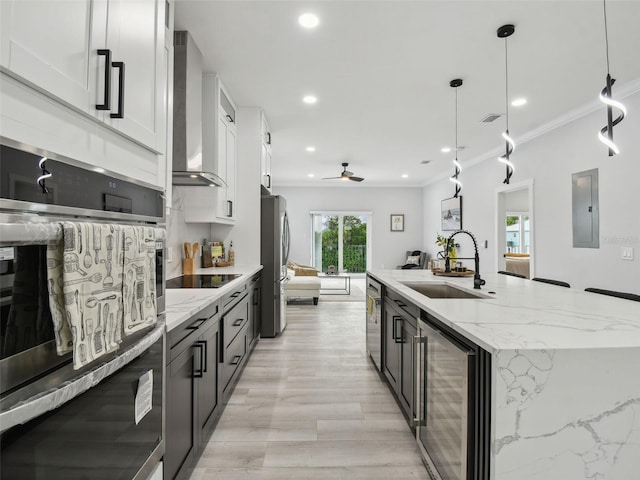 3380 Holly Springs Dr, Hernando Beach, FL 34607 - kitchen featuring beverage cooler, wall chimney exhaust hood, stainless steel appliances, ceiling fan, and a kitchen island with sink