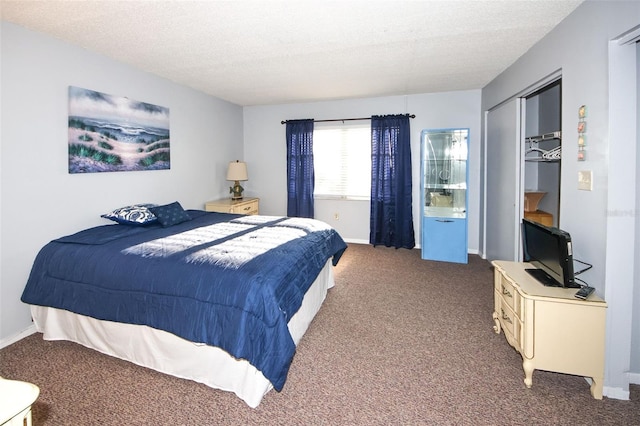 carpeted bedroom with a closet and a textured ceiling