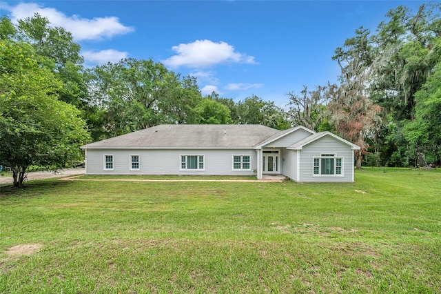 rear view of property featuring a lawn