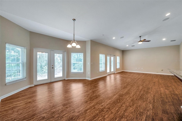 unfurnished living room featuring a healthy amount of sunlight, french doors, dark hardwood / wood-style floors, and ceiling fan with notable chandelier