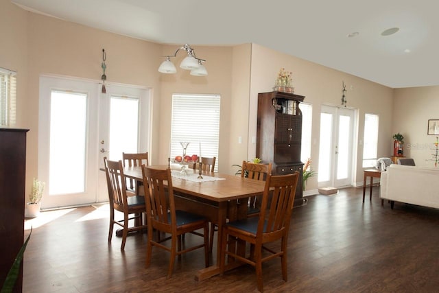 dining space with french doors, dark hardwood / wood-style floors, and a notable chandelier