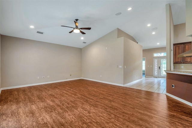 unfurnished living room with ceiling fan, light hardwood / wood-style floors, lofted ceiling, and french doors