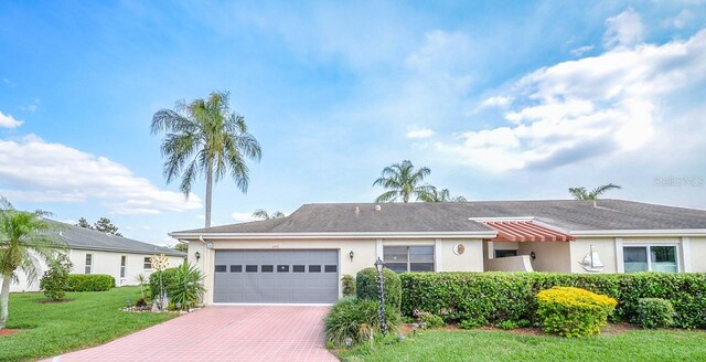 ranch-style house featuring a front lawn and a garage