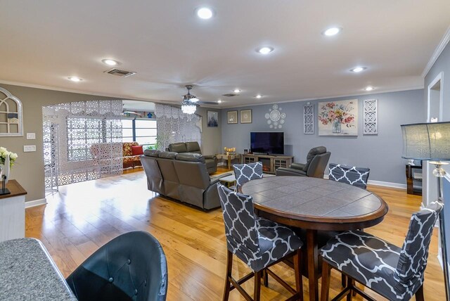 dining space featuring crown molding, ceiling fan, and light hardwood / wood-style flooring