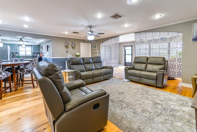 living room with light hardwood / wood-style flooring, ceiling fan, and crown molding