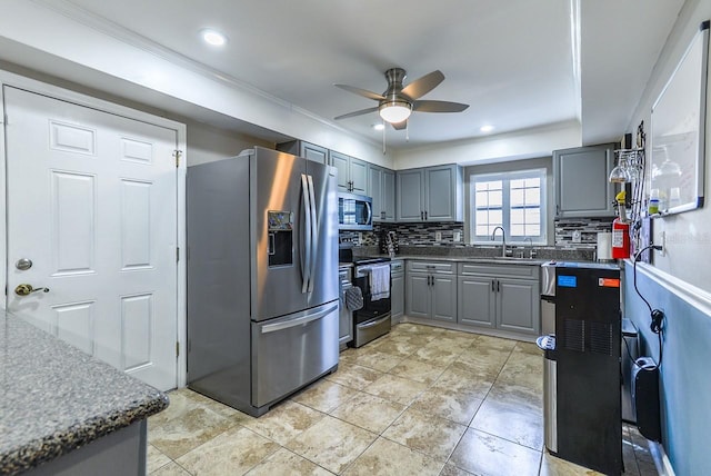 kitchen with ceiling fan, gray cabinets, appliances with stainless steel finishes, light tile flooring, and tasteful backsplash