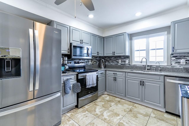 kitchen featuring backsplash, ceiling fan, sink, stainless steel appliances, and gray cabinets