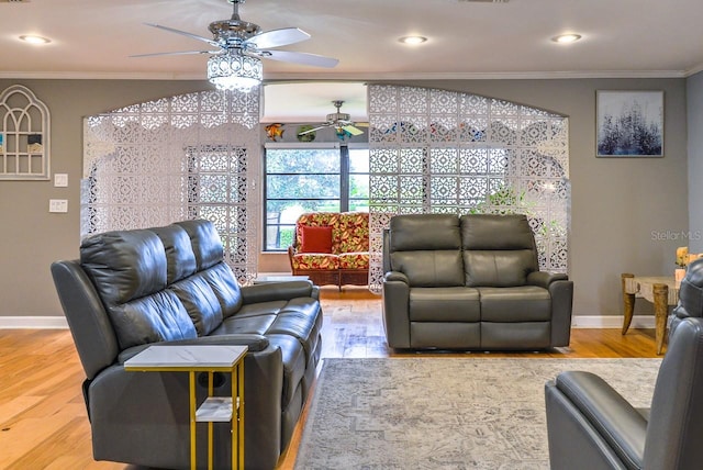 living room with ceiling fan, light wood-type flooring, and ornamental molding