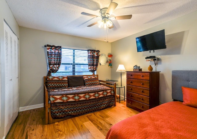 bedroom featuring ceiling fan, light wood-type flooring, and a closet