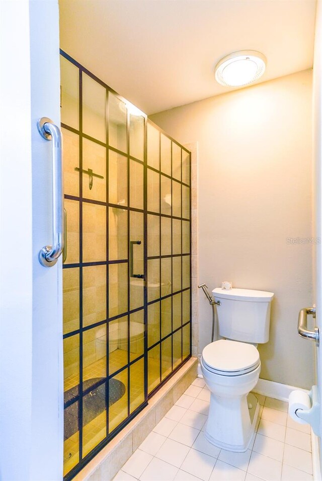 bathroom with a shower with shower door, toilet, and tile floors