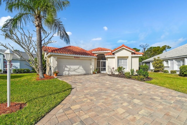 mediterranean / spanish home featuring a front yard and a garage