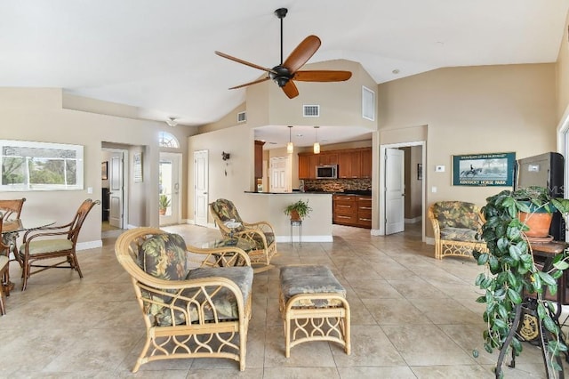 tiled living room with ceiling fan and high vaulted ceiling