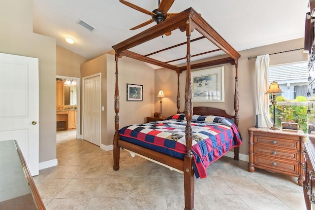 tiled bedroom featuring lofted ceiling, ensuite bath, a closet, and ceiling fan