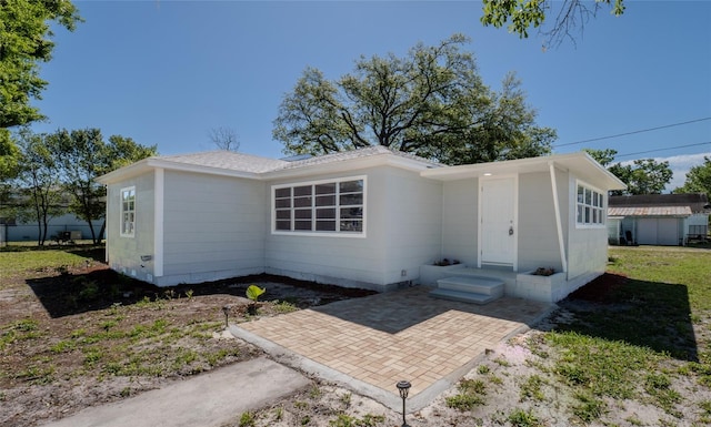 ranch-style house with a patio area and a storage shed