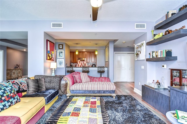 living room with hardwood / wood-style flooring and a textured ceiling