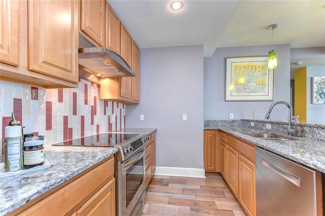 kitchen featuring light stone counters, appliances with stainless steel finishes, sink, and light wood-type flooring