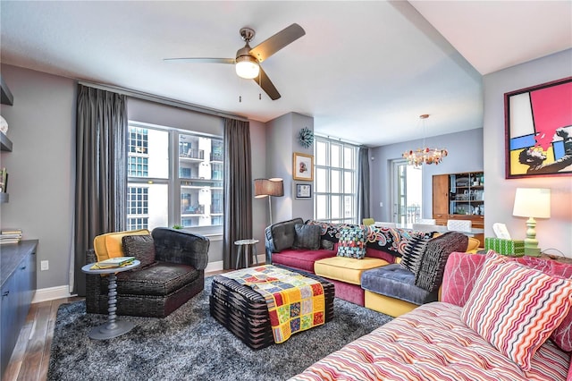 living room featuring ceiling fan with notable chandelier and hardwood / wood-style floors