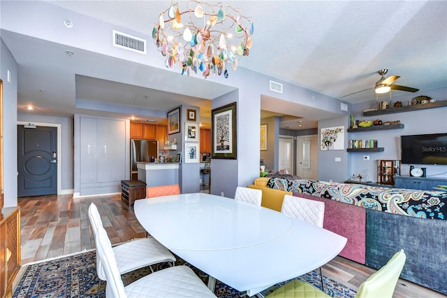 dining room with a textured ceiling, ceiling fan, and hardwood / wood-style flooring