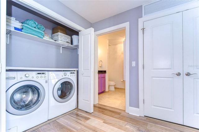 laundry room featuring washer and dryer and light wood-type flooring