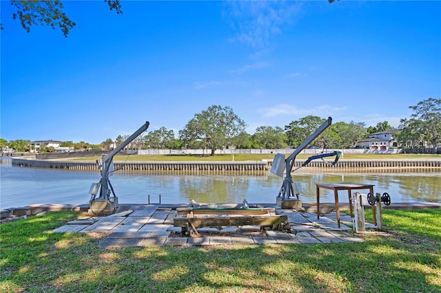 view of dock with a water view and a yard