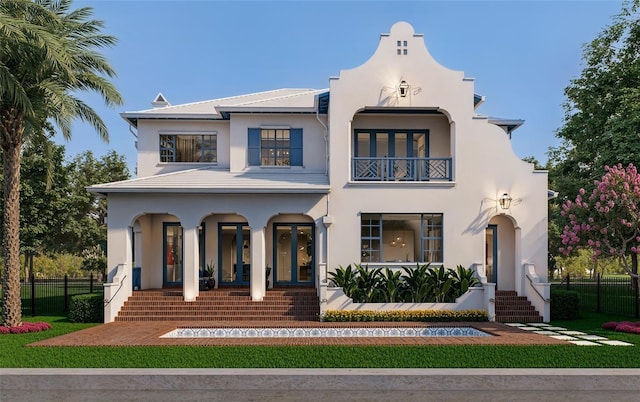 mediterranean / spanish-style home with fence, a balcony, and stucco siding