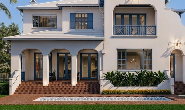 view of front of property featuring covered porch, a balcony, and stucco siding