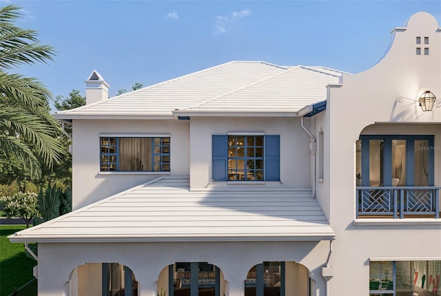 rear view of property featuring stucco siding