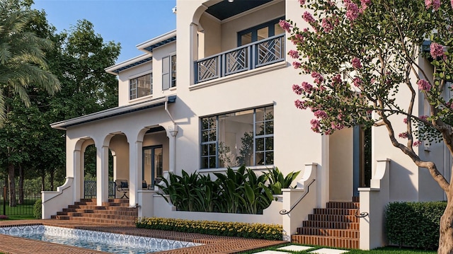 doorway to property with a balcony and stucco siding