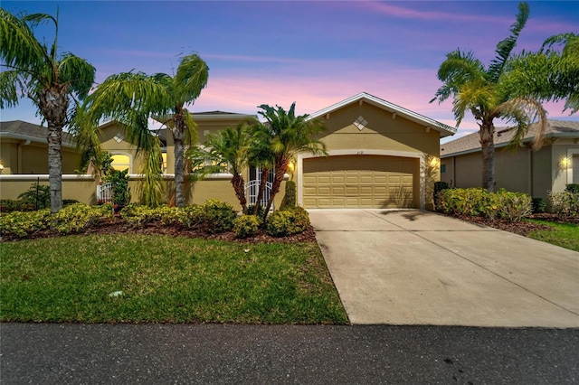 view of front facade with a yard and a garage