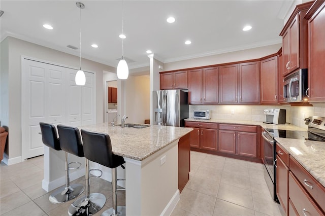 kitchen featuring appliances with stainless steel finishes, a breakfast bar, light stone counters, tasteful backsplash, and pendant lighting