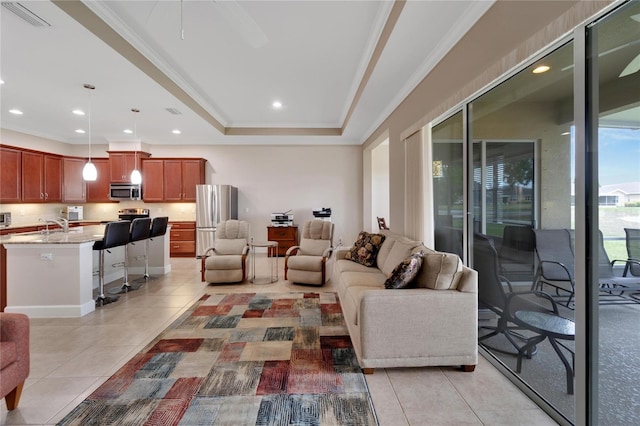 living room with light tile floors, ceiling fan, crown molding, and a raised ceiling