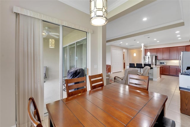 tiled dining area featuring a raised ceiling, ceiling fan, and ornamental molding