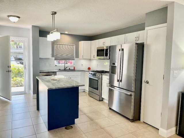 kitchen featuring decorative light fixtures, tasteful backsplash, stainless steel appliances, and white cabinetry