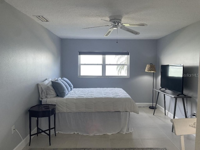 bedroom with light tile floors, ceiling fan, and a textured ceiling