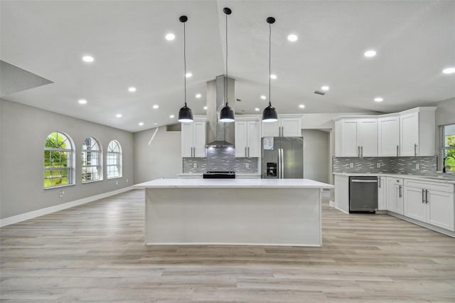 kitchen with light hardwood / wood-style floors, hanging light fixtures, tasteful backsplash, and stainless steel appliances