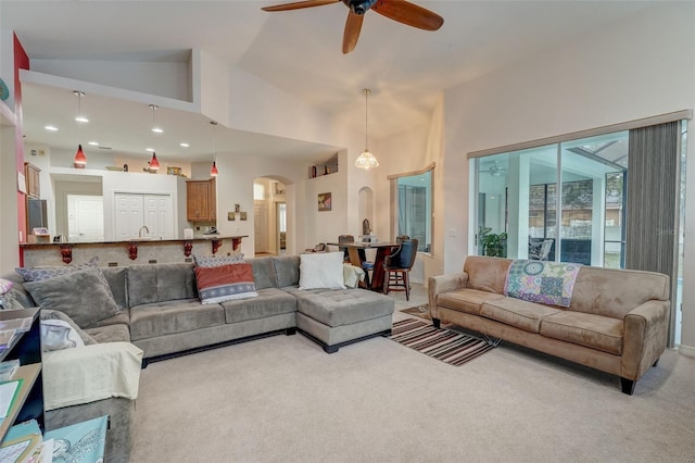 living room featuring light carpet, ceiling fan, and high vaulted ceiling