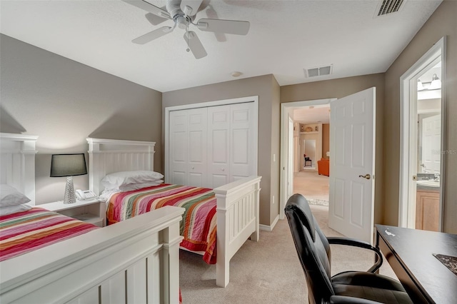 bedroom featuring a closet, light colored carpet, and ceiling fan