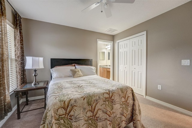 carpeted bedroom featuring a closet, ceiling fan, and ensuite bathroom