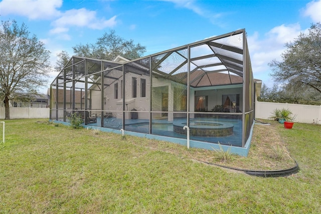 rear view of property with a lawn, glass enclosure, and a swimming pool with hot tub