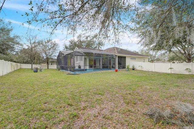 rear view of house featuring glass enclosure, a yard, and a swimming pool