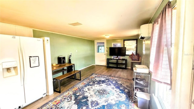 kitchen with white fridge with ice dispenser, dark wood-type flooring, and a wall unit AC