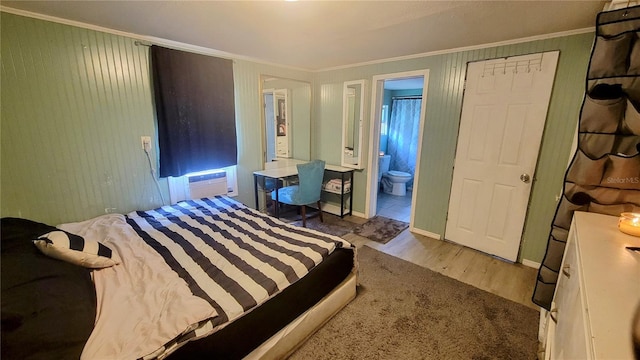 bedroom featuring ensuite bath, light wood-type flooring, and crown molding