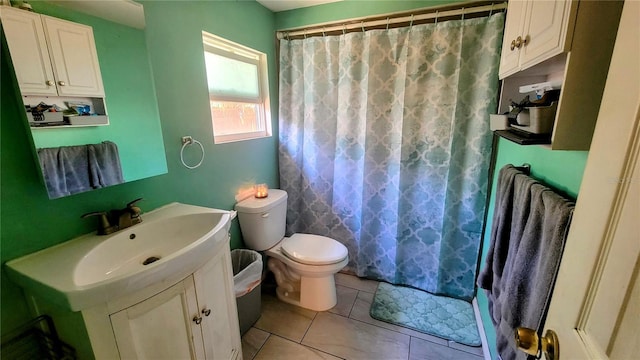 bathroom with toilet, tile flooring, and vanity