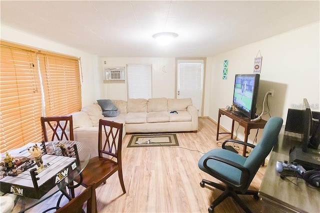 living room with an AC wall unit and light wood-type flooring